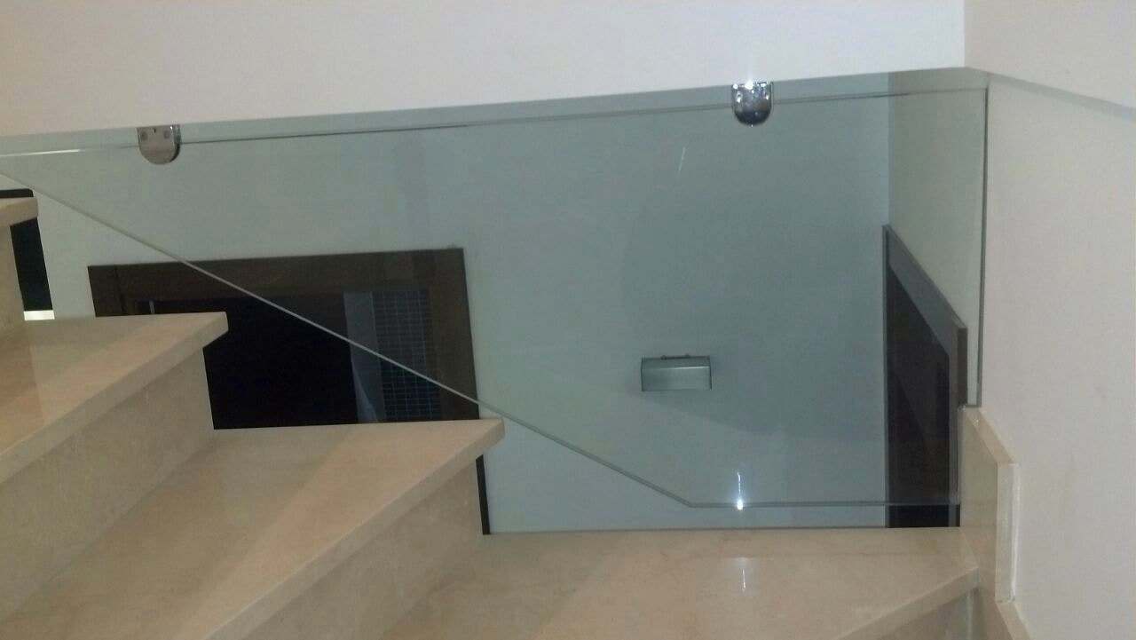 Panel de vidrio que cierra el hueco de una escalera de mármol