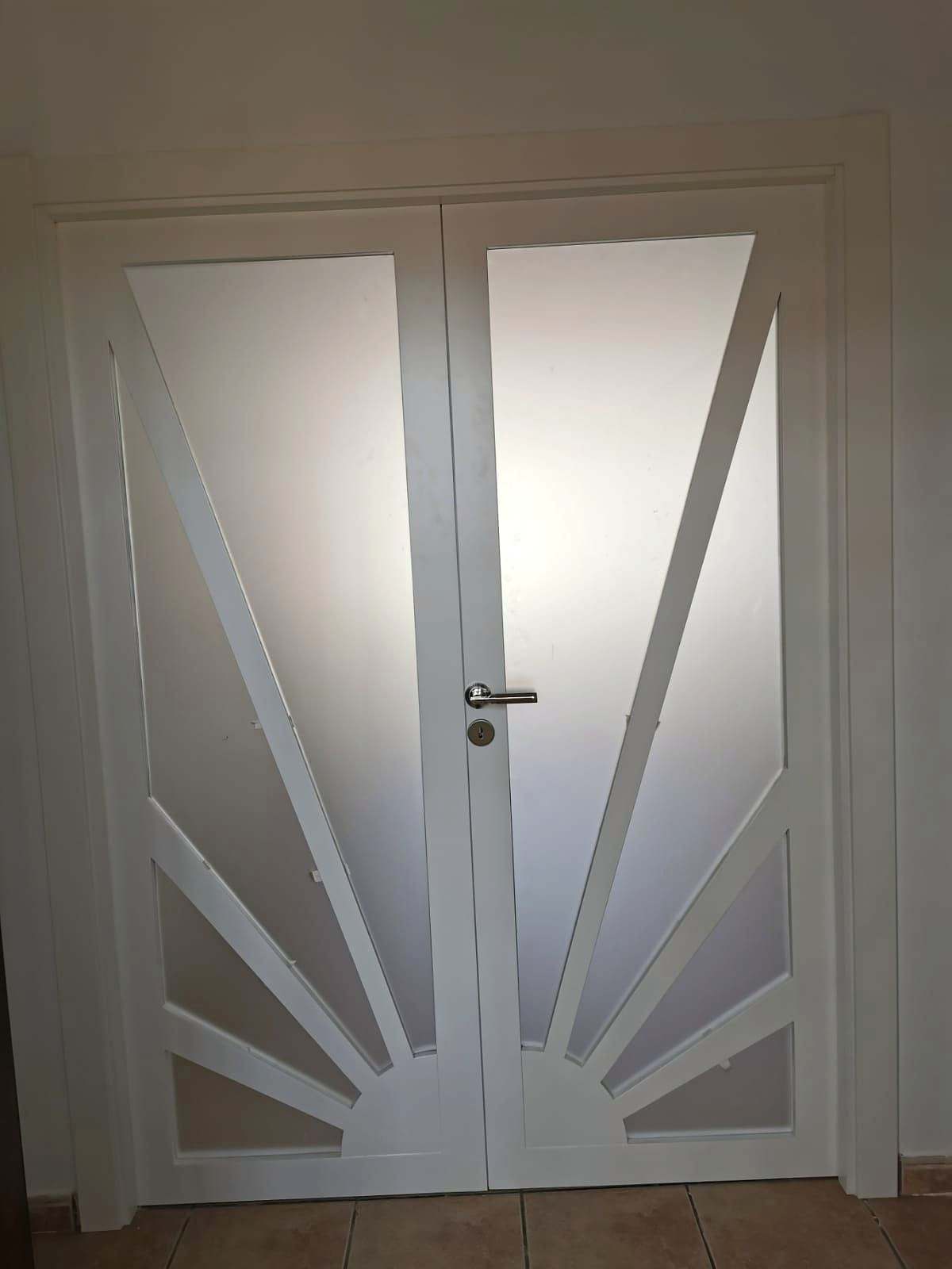 Puerta doble blanca con vidrios mate recortados en forma de rayos