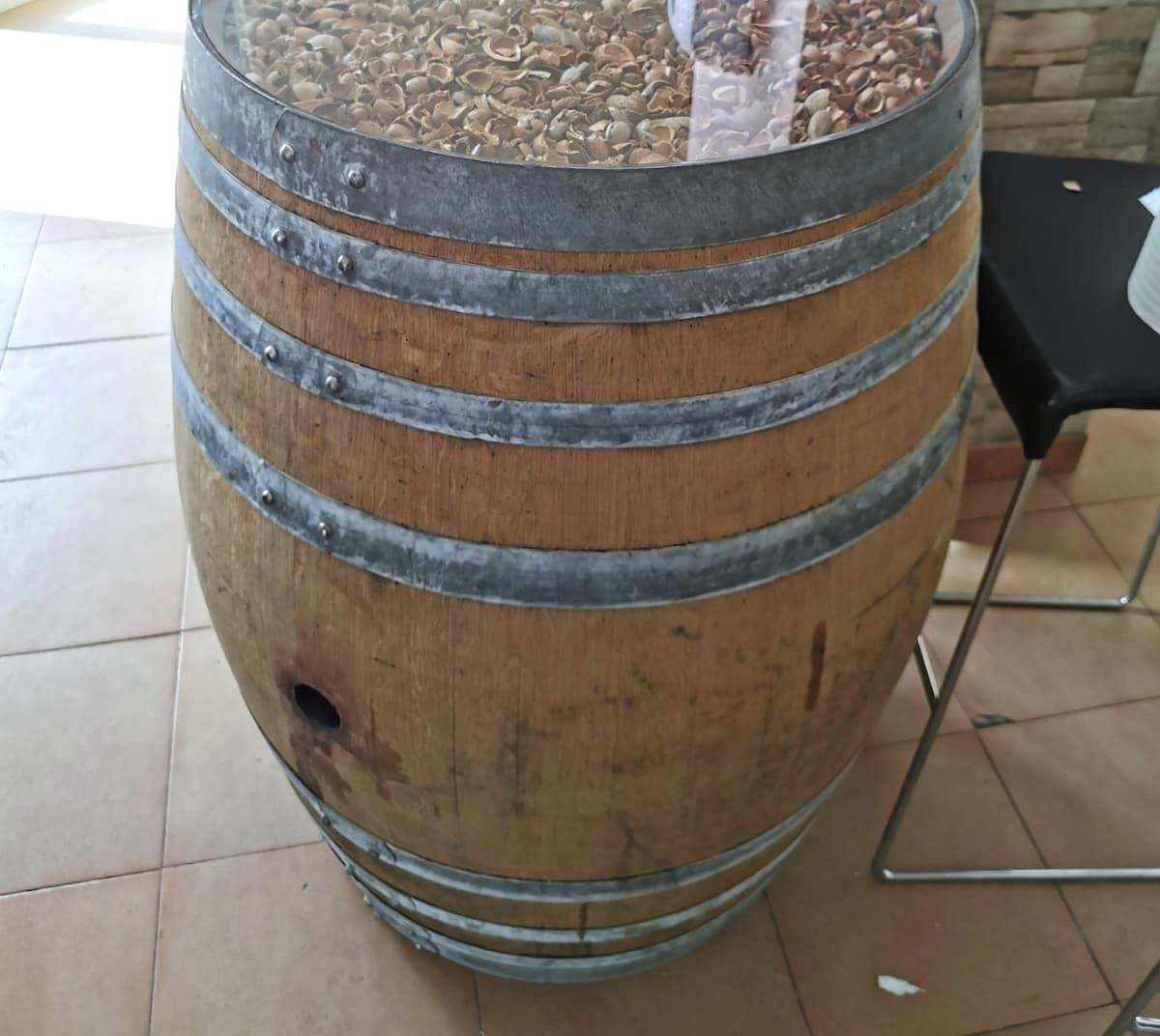 Barril de vino abierto convertido en mesa, cerrado con una tapa de cristal que deja ver el interior